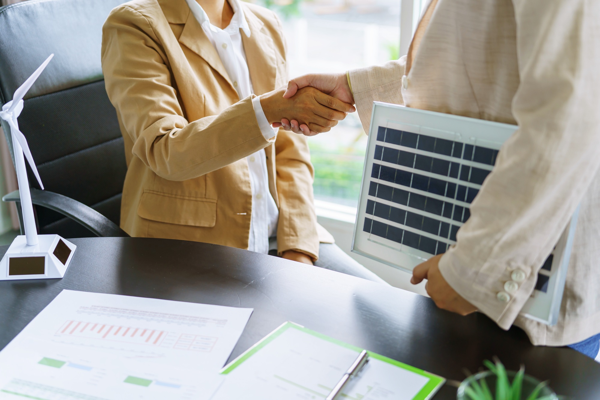 handshake and business with solar panels green energy business people working
